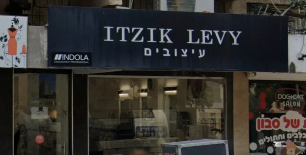 חזית המספרה: שלט כחול כהה עם הכיתוב Itzik Levy עיצובים מעל חלון ראווה